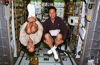 Mission specialists Jean-Francois Clervoy (left) and Ed Lu (right) float in the shuttle's spacehab.